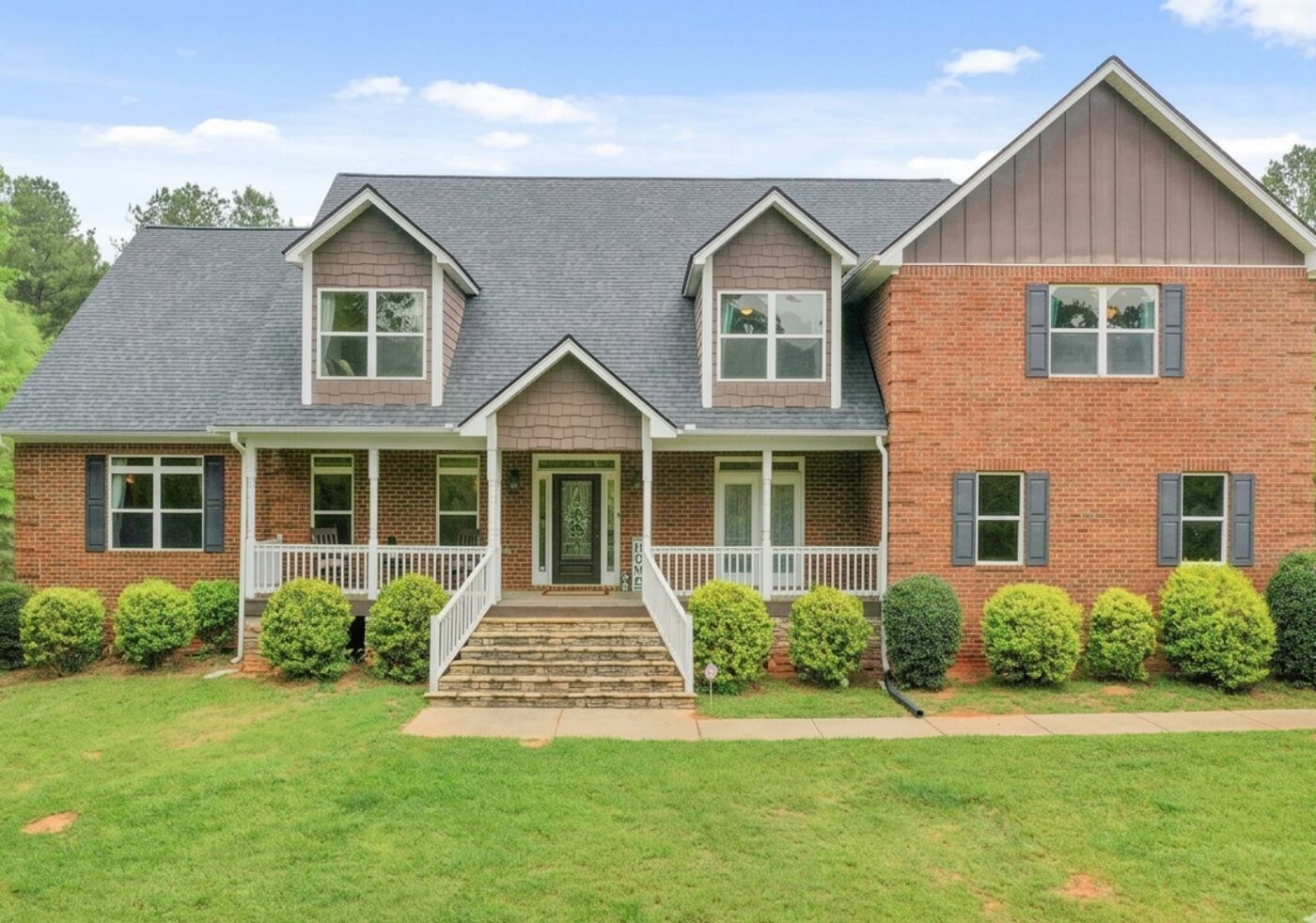 Brick and cedar-shake custom home renovation with covered entry.