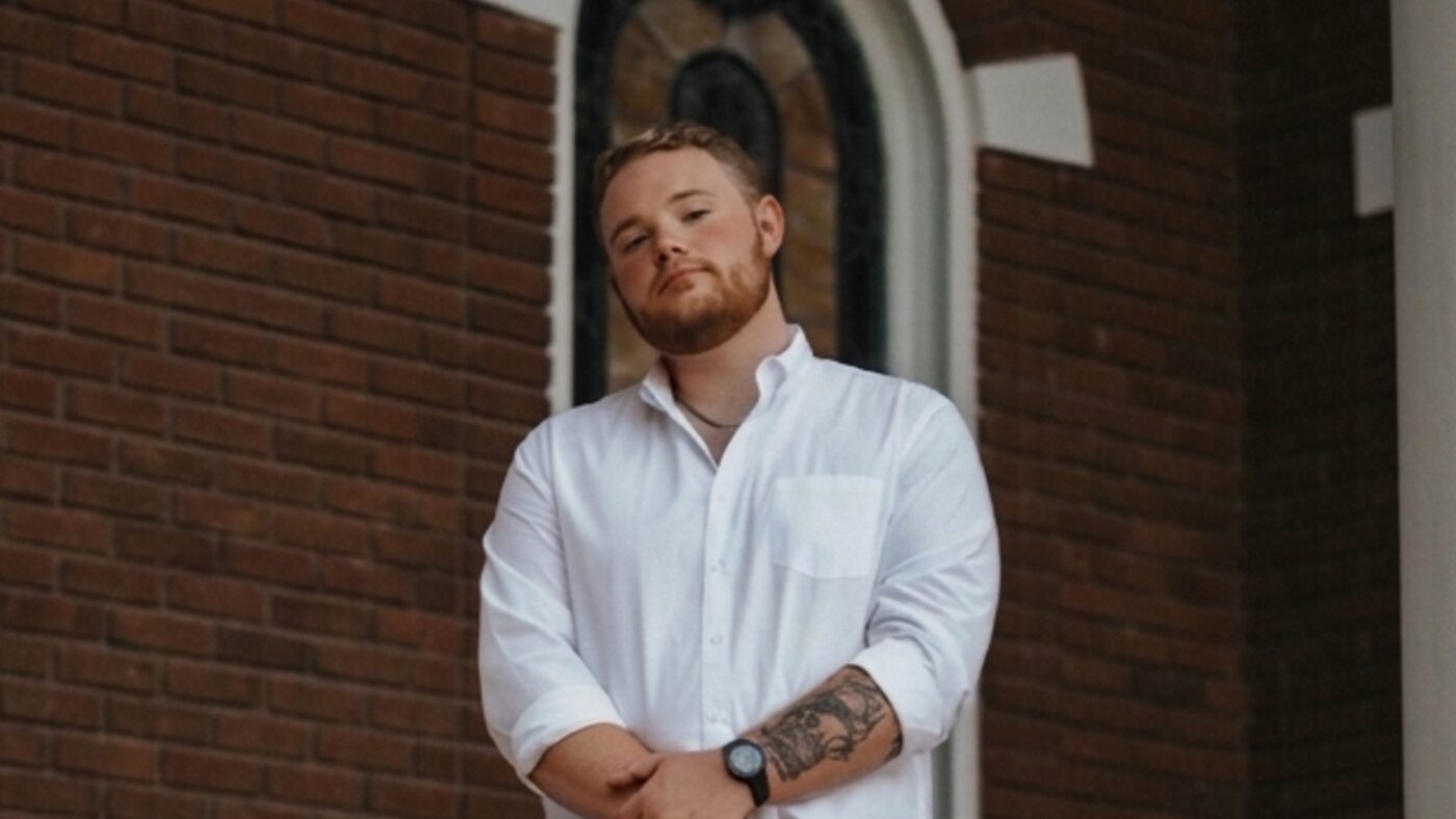 Josh Bannister, owner of Bannister Custom Homes, standing at a brick entryway.